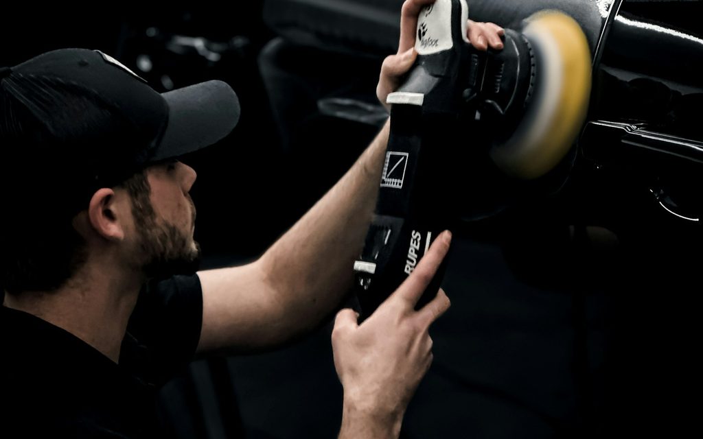 A detailer cleaning a car interior with a machine